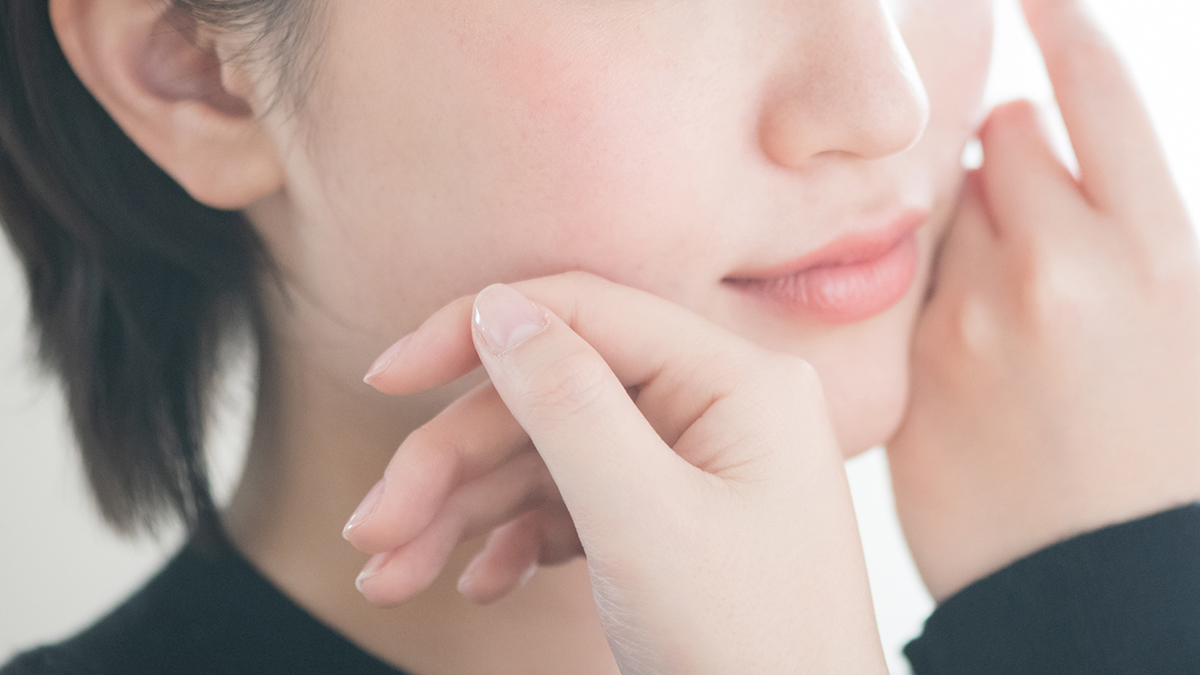 肌に手を当てる女性